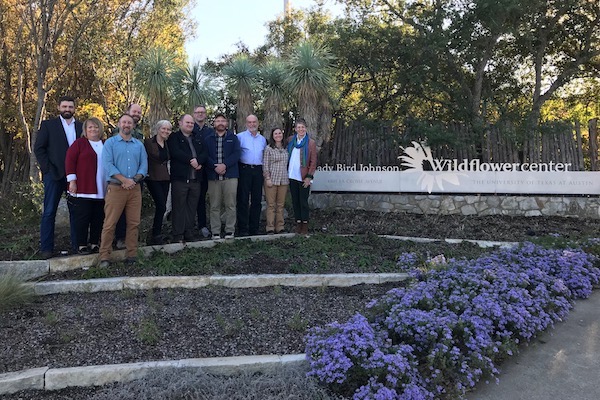 Members of SGI and the Wildflower Center meet in front of the center's front sign.