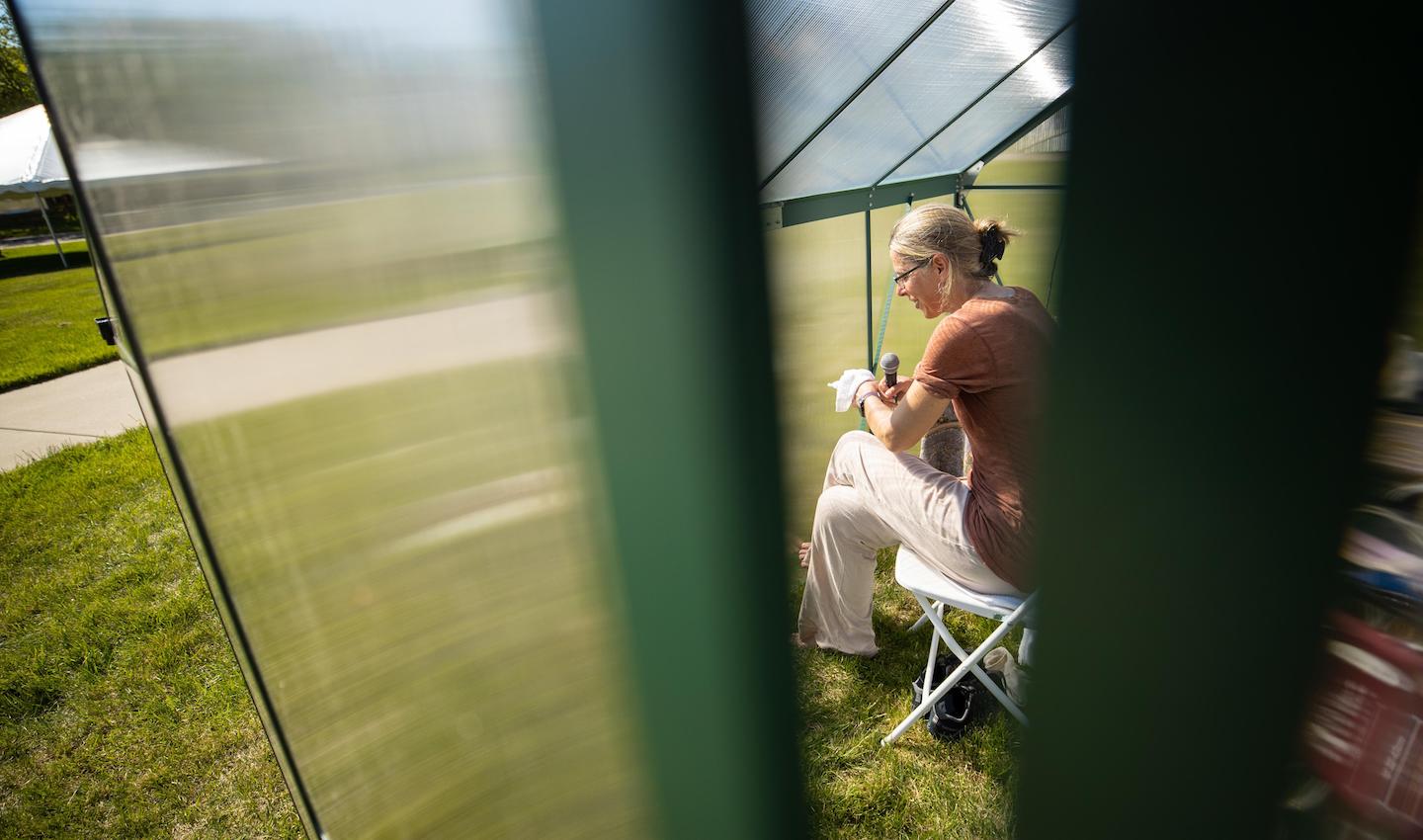 On Earth Day, the Art + Design lawn at Austin Peay State University had an interesting sight to see. Eliza Evans, an environmental artist of about 10 years, was taking part in a durational performance piece where she spent several hours in a “time machine.” This time machine, a commercial greenhouse, helped to show what the future may look like on Earth. Instead of using statistics and graphs to indicate the changes in the environment, Evans used her body as a proxy. During this performance, Evans stayed in the time machine for seven hours. Through this, the experiment showed how the human body copes with the effects of the environment, much like the Earth. “This is just an experiment for me to try to anticipate what the world might be like towards the end of my life,” Evans said. Evans referred to this art piece as a “personal exploration.” She also shared the experience with those brave enough to step into the time machine. I had the opportunity of experiencing what Eliza was while also getting to know her better. I stayed in the time machine for a little over 13 minutes, but only a few minutes in, I felt extremely uncomfortable. Evans discussed how our shared traits allow us to adapt and create solutions together to combat issues we face. “We have a problem, and we don’t know how bad it is going to be. We need to help each other,” Evans said. This is not Evans’ first time undergoing this durational performance piece. When Evans was on an artist’s residency in New York, she put out a greenhouse on a lawn as an experiment to see what would happen. Evans said the people who brought her fruit and ice on their own showed her how beautiful this experiment is. “They just pitched in,” Evans said. “That wasn’t even a question I posed.” The experiment Evans participated in on APSU’s campus had more structure. In the first experiment Evans conducted, she kept track of her heart rate thinking she could take care of her own health. This performance was also a collaboration with the APSU School of Nursing. Nursing students took Evans’ vitals throughout her performance to see how the heat was affecting her. “This project has already created a context for the community nursing projects on water quality and community health,” Evans said. “These two projects are in conversation with each other which I think is phenomenal.” Evans’ goal is to make people aware of the effects Earth is undergoing. “Even if they disagree, even if someone isn’t quite convinced that climate change is real or that it’s caused by humans, people have positions all along the spectrum, and I’m willing to engage with any,” Evans said. Evans said she finds conversations with others about her art is a rewarding part of the process. Evans saw the Earth Day performance as a perfect opportunity to help bring awareness to climate change and its effects on the Earth. “Every day is Earth Day to me,” Evans said. Visit Evans’ website to learn more about her work. The performance was sponsored by the Department of Art + Design with support from The Center of Excellence for the Creative Arts.