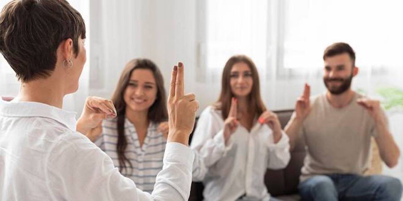 A stock photo of an instructor teaching ASL to students.
