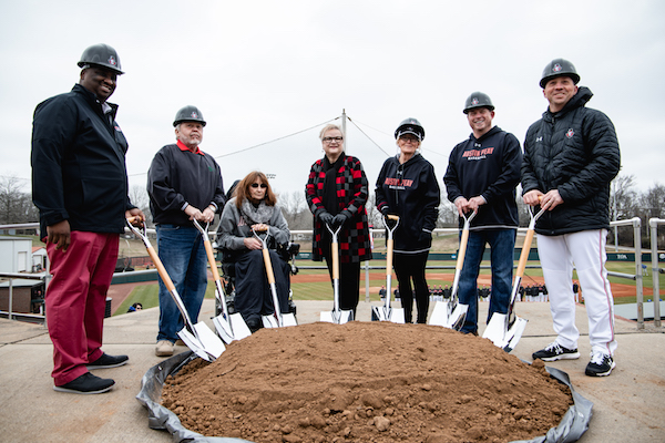 The donors and President White stand with shovels at the baseball field.