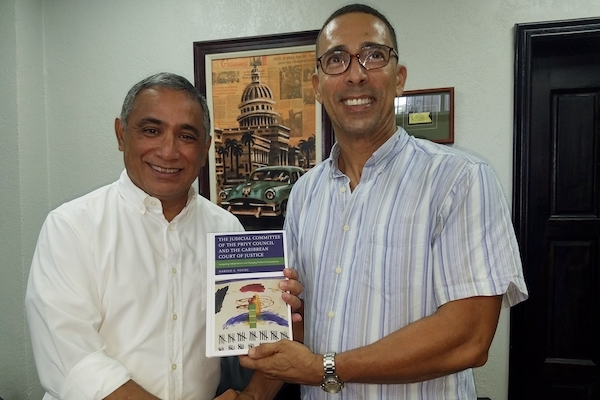 Dr. Young presents his book to then leader of opposition, now prime minister, Honorable John Briceño 