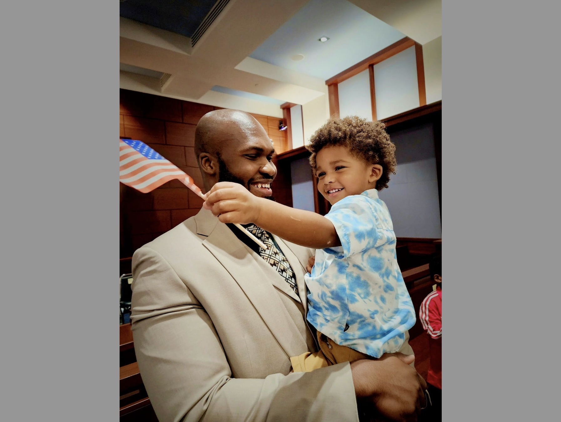 Emmanuel Méjeun celebrates with his 2-year-old son, Luka, after completing the requirements to become a U.S. citizen at a naturalization ceremony earlier this year. 