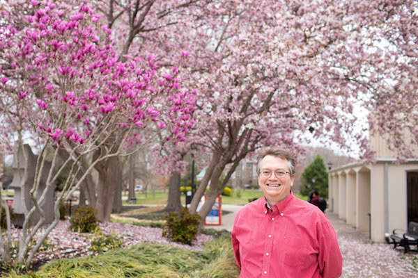 Brian Dunn stands outside the APSU library as trees begin to bloom.