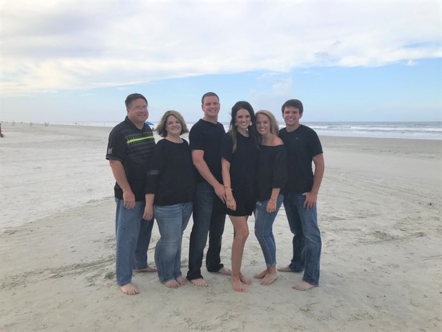Duvall Family standing on a beach. 
