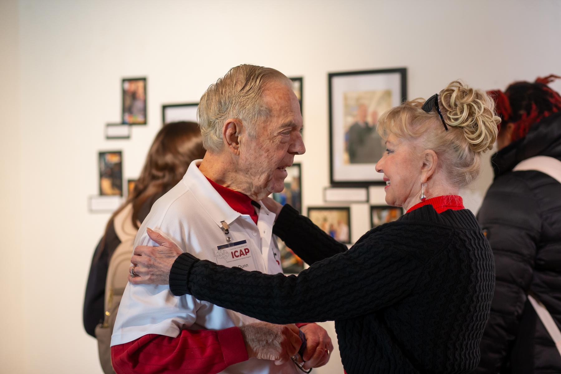 Jim Dunn and his wife, Pat, share an embrace during the CCC-ICAP’s closing photo exhibition. 