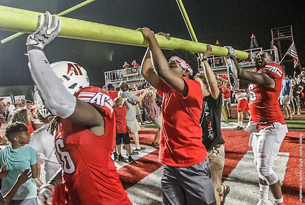 Players and fans take down the goal posts at Fortera Stadium.