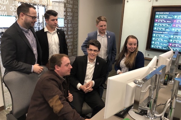 APSU business students talk about investing around a computer.