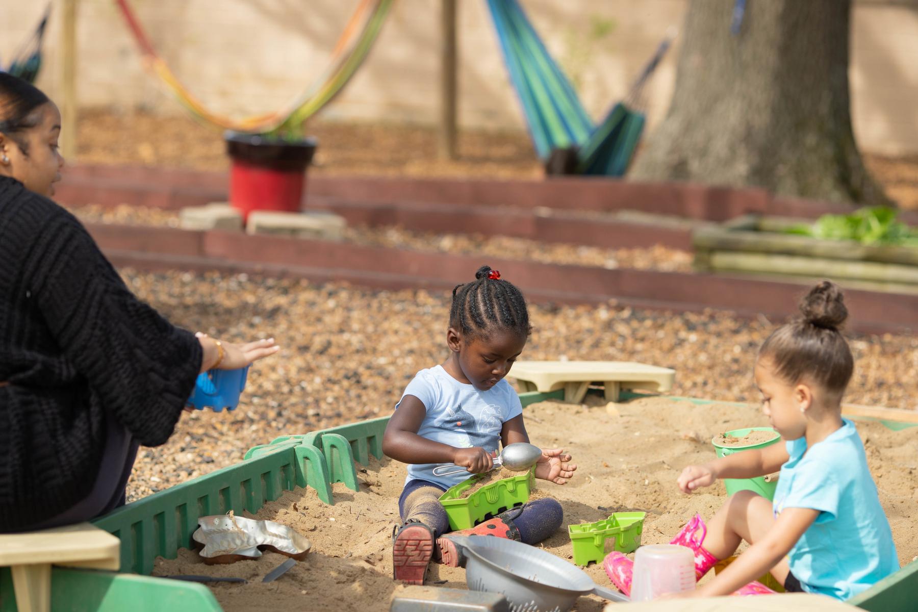 Children play in the sandbox at Little Govs Child Learning Center.