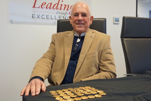 John McGee with gold coins he donated.