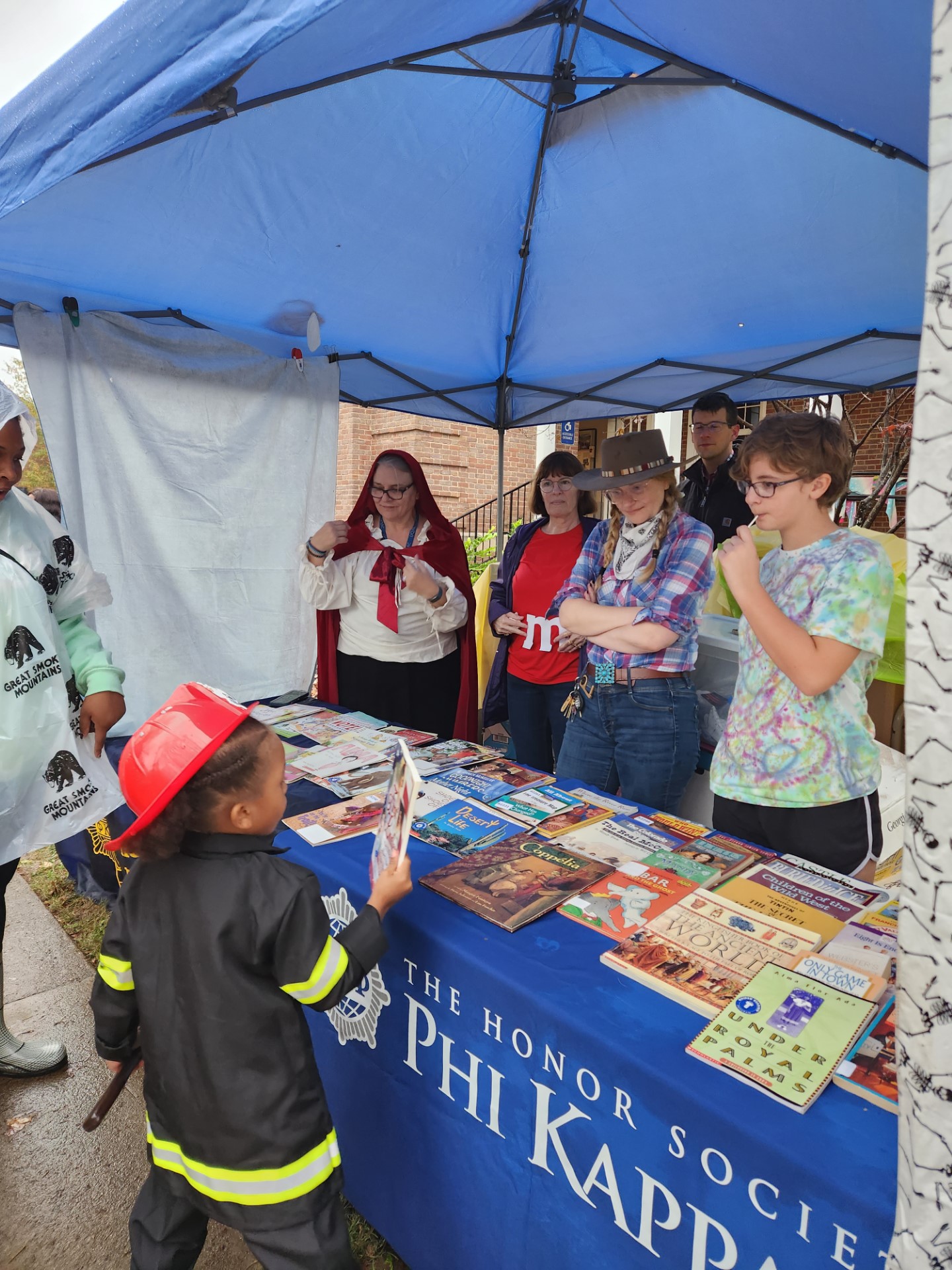 A child picks out a book at Phi Kappa Phi's Candy for the Mind event.