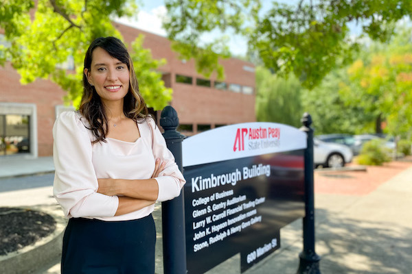 Dr. Saglam standing, arms crossed, in front of the Kimbrough Building at APSU.