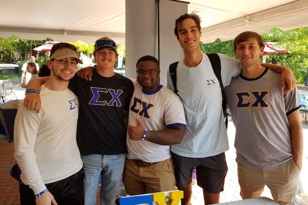 Four fraternity members pose for a photo (names not provided).