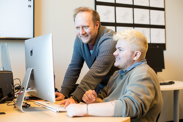 APSU animation professor Scott Raymond works with a student on a digital animation project.