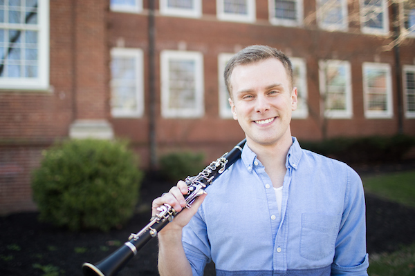 Hayden Giesseman holds his clarinet in front of Music Building on campus.