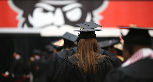 The back of a student's head during commencement, with the Gov logo looking on.