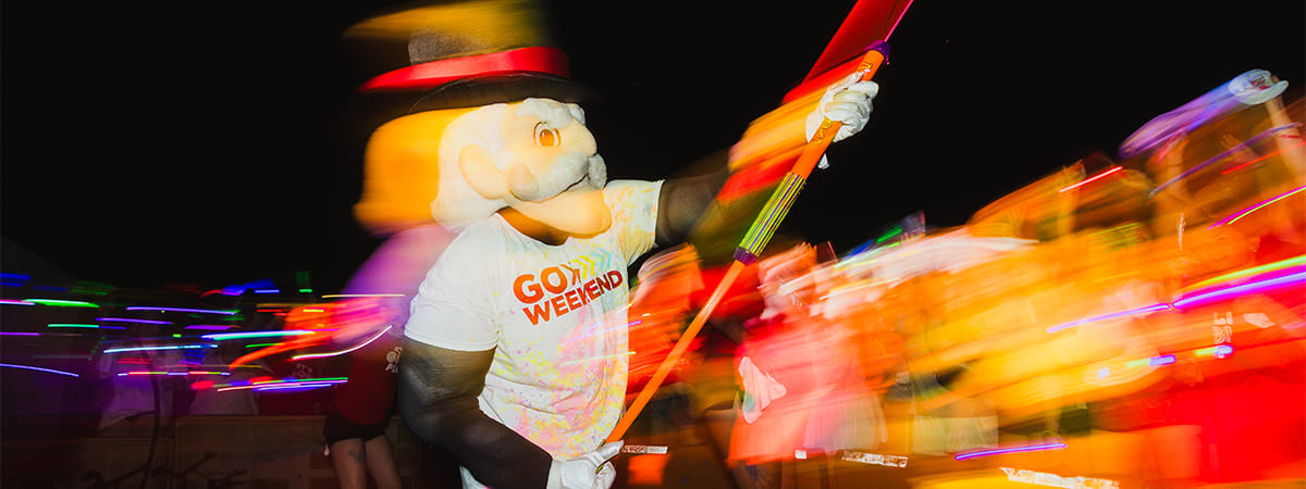 The Governor mascot shooting glow paint into the crowd during the Glowchella event.