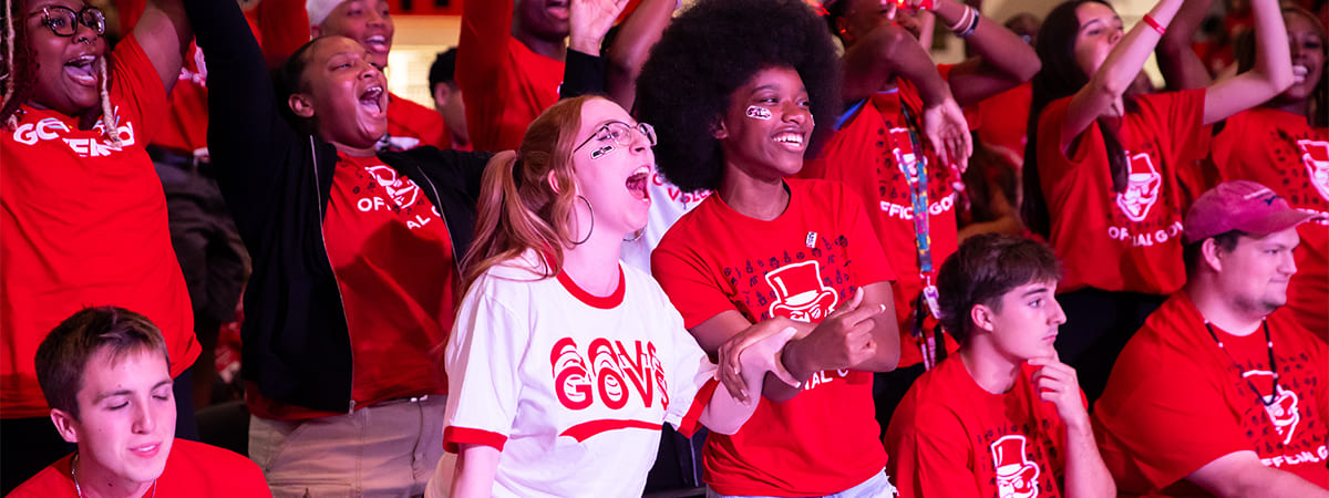 Enthusiastic new students at an event, wearing APSU red shirts and cheering.
