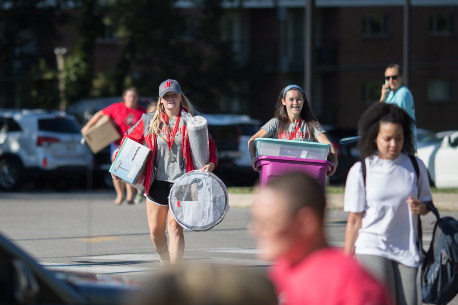 Helpers carrying student's stuff to the dorm