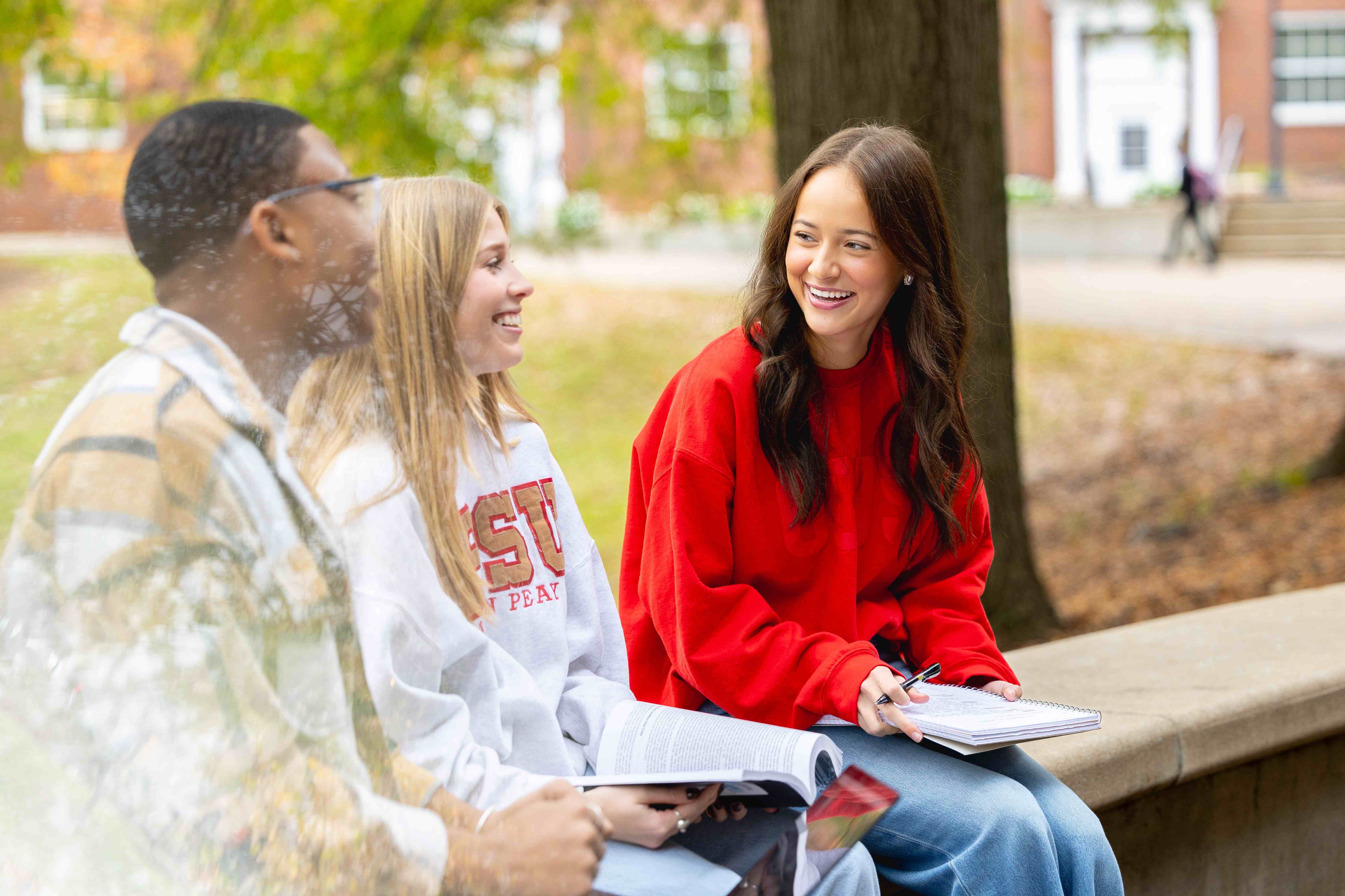 Student sit outside the UC, studying under trees
