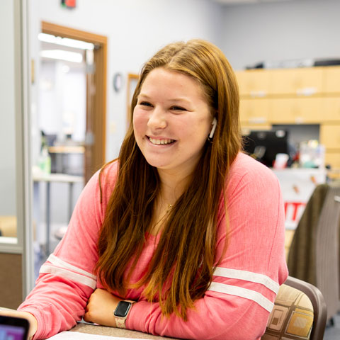 Student laughing and working on a laptop
