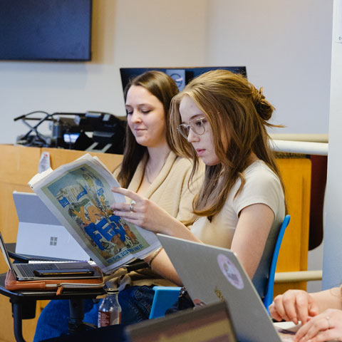 Student reading a newspaper in class