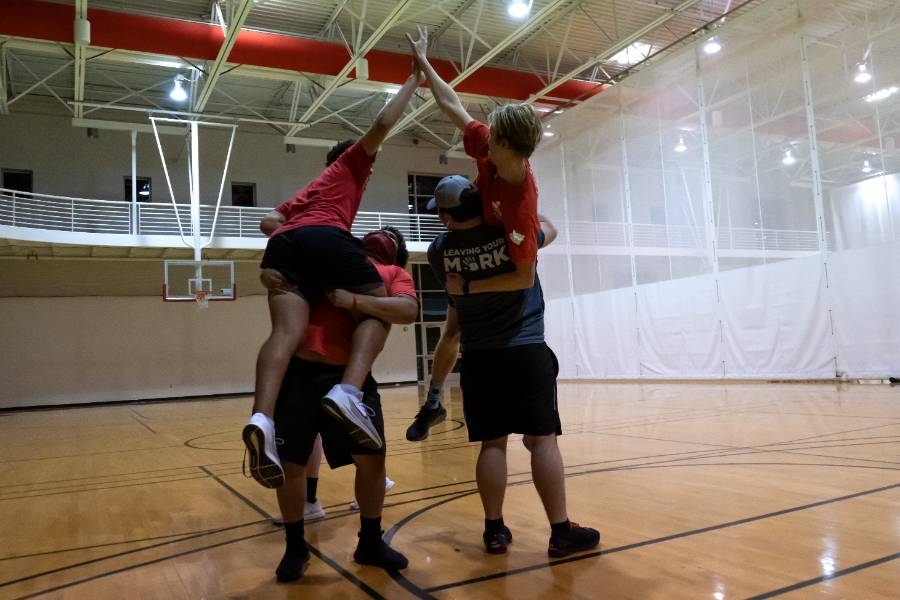 students high-fiving after intramural win on the Foy Center gym courts
