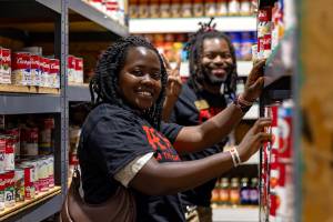 Workers enjoying their time stocking food pantry shelves.