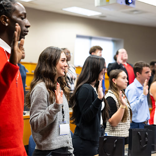 New SGA members standing and raising their right hands while being sworn in to office.