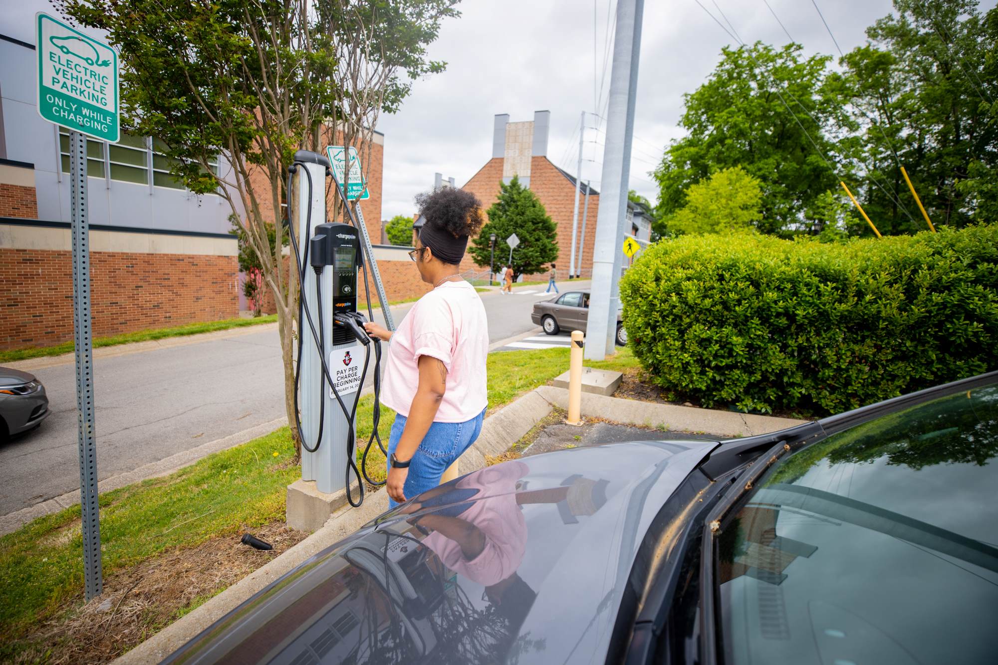 Student about to charge her electric car on campus