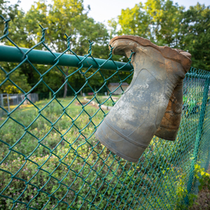 Pair of rubber boots hangning on a fence