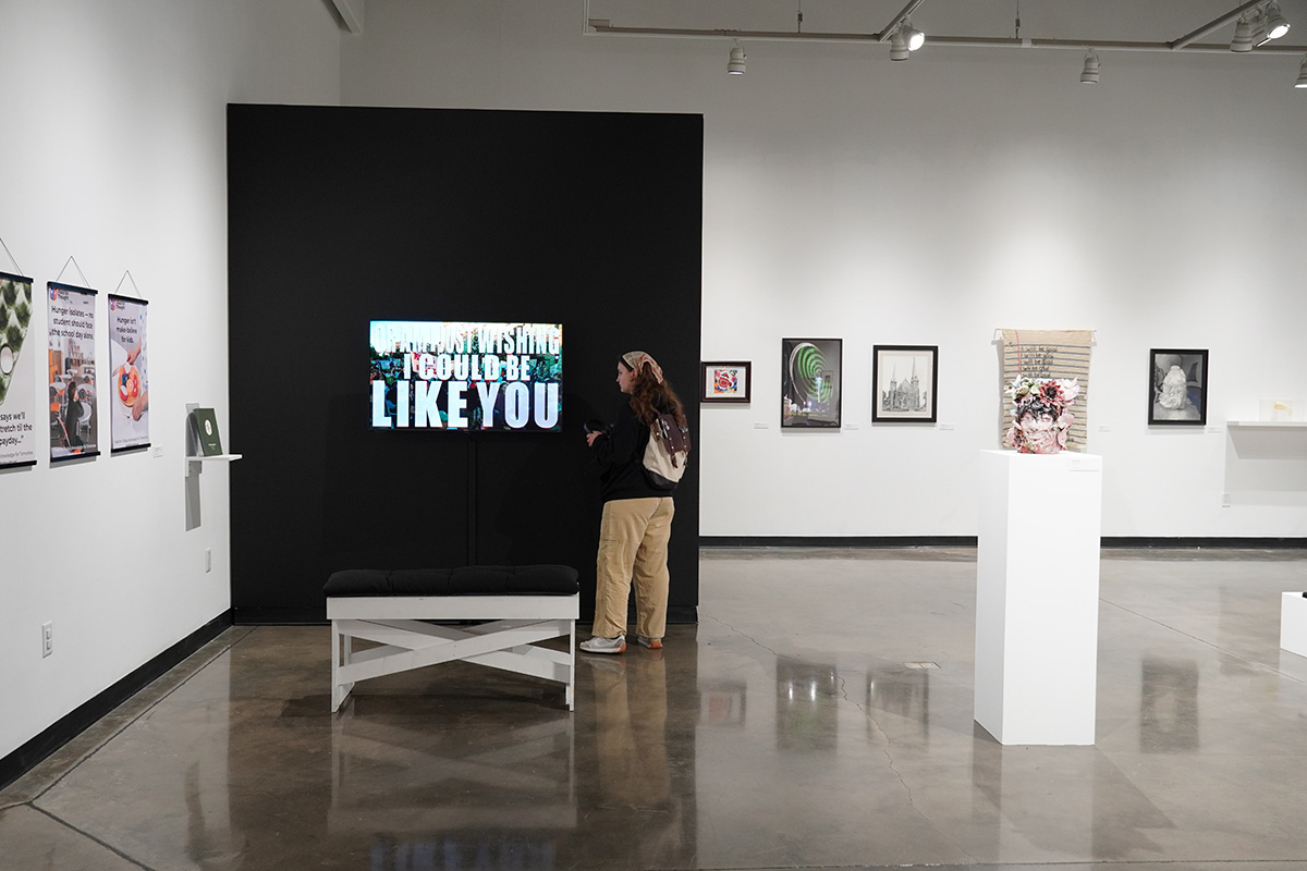 A modern art gallery with various framed artworks and a digital display.