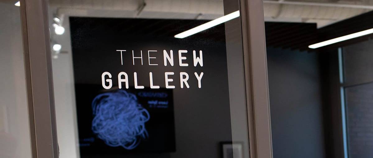 "The New Gallery" lettering on the glass wall entrance of the gallery.