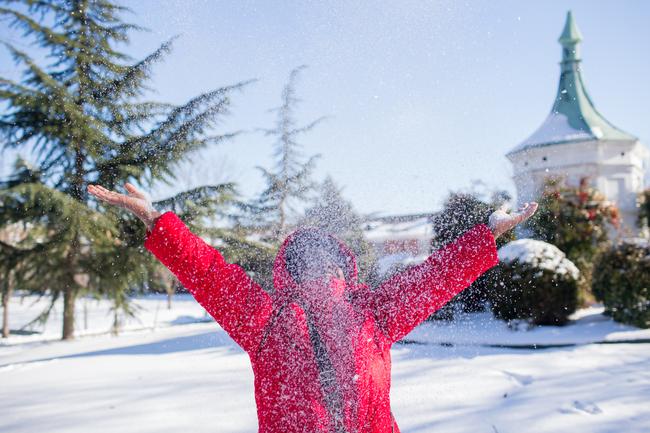 student happily throwing snow into the air